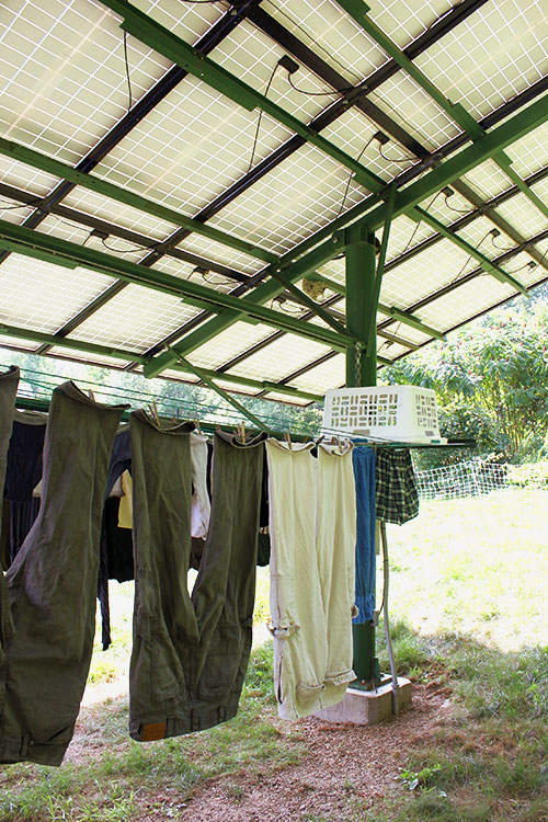 Clothes drying on line underneath solar panels.